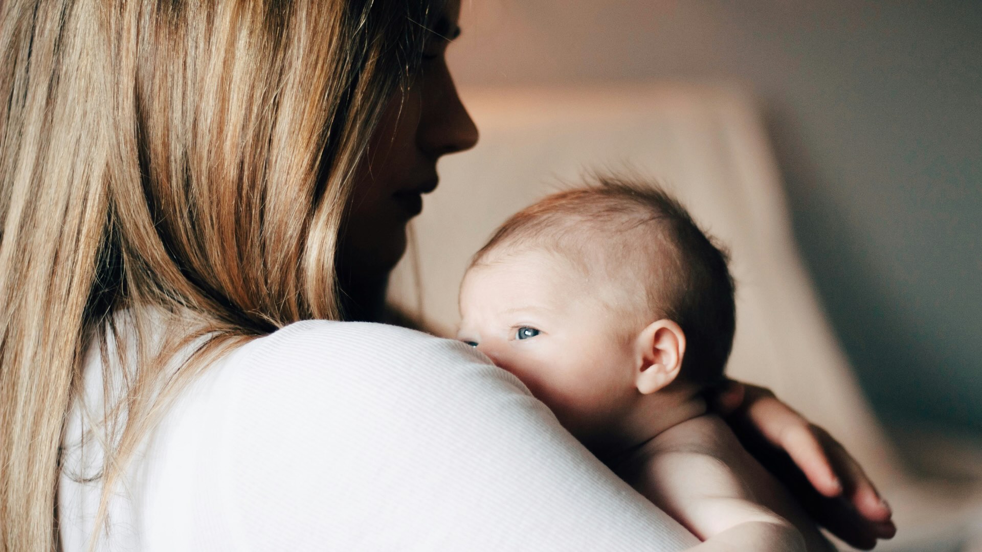 Foto di una mamma con un neonato in braccio